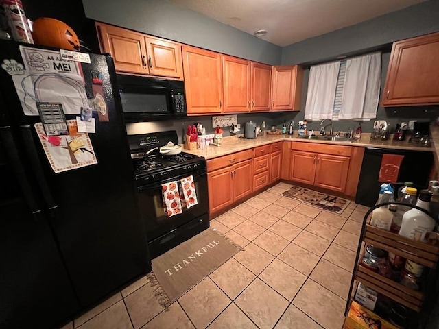 kitchen featuring black appliances, light tile patterned floors, and sink