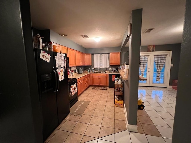 kitchen featuring black appliances, light tile patterned floors, sink, and french doors