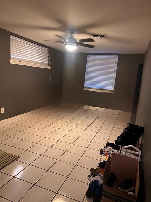 tiled empty room with ceiling fan