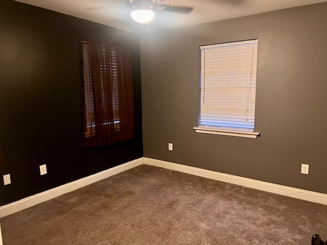 unfurnished room featuring ceiling fan and dark carpet