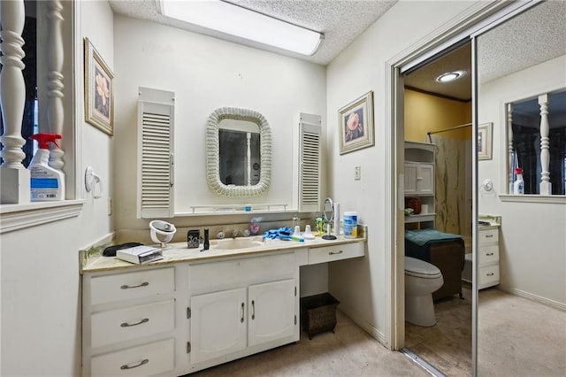 bathroom featuring vanity, toilet, and a textured ceiling