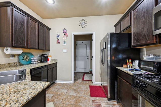 kitchen with black appliances, dark brown cabinetry, light stone countertops, and sink