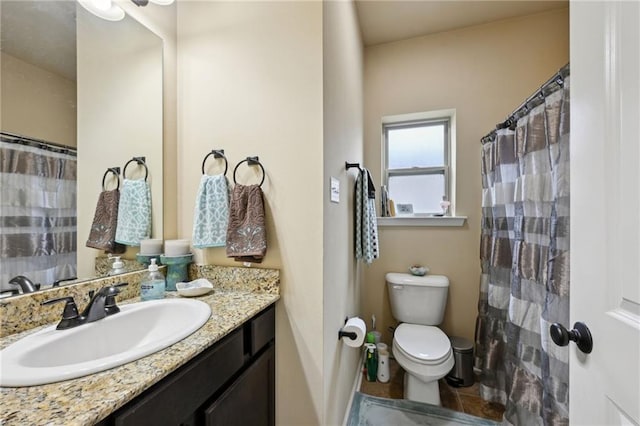 bathroom with curtained shower, vanity, and toilet