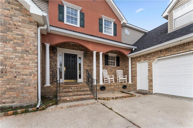 view of exterior entry featuring a porch and a garage