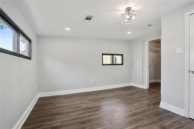 unfurnished bedroom featuring dark hardwood / wood-style floors, a spacious closet, and a closet