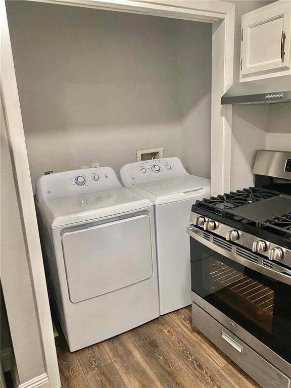 laundry area with washing machine and dryer and dark wood-type flooring