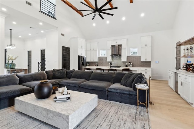living room with ceiling fan, light hardwood / wood-style flooring, and high vaulted ceiling
