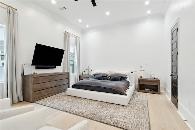 bedroom featuring ceiling fan, light wood-type flooring, and crown molding