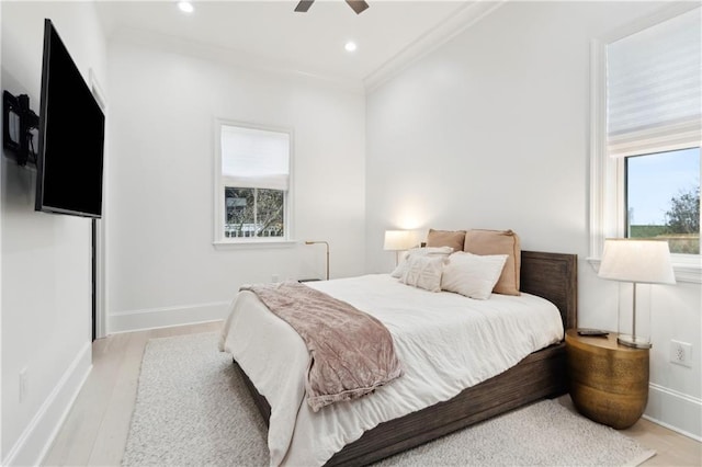 bedroom with light hardwood / wood-style flooring, ceiling fan, and crown molding