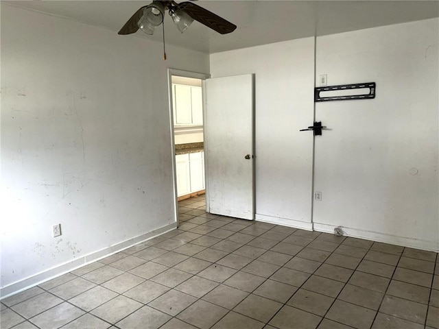 empty room featuring tile patterned floors and ceiling fan