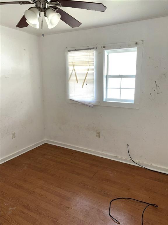 unfurnished room featuring dark hardwood / wood-style floors and ceiling fan