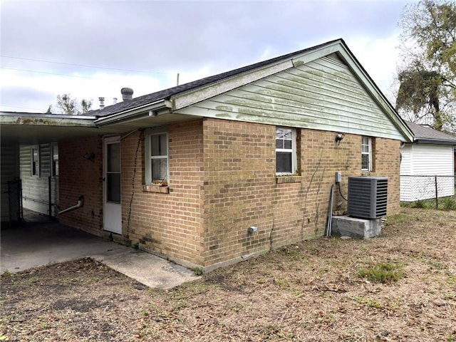 view of side of home featuring central AC and a carport