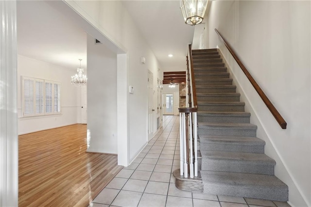 stairs featuring tile patterned floors and a notable chandelier