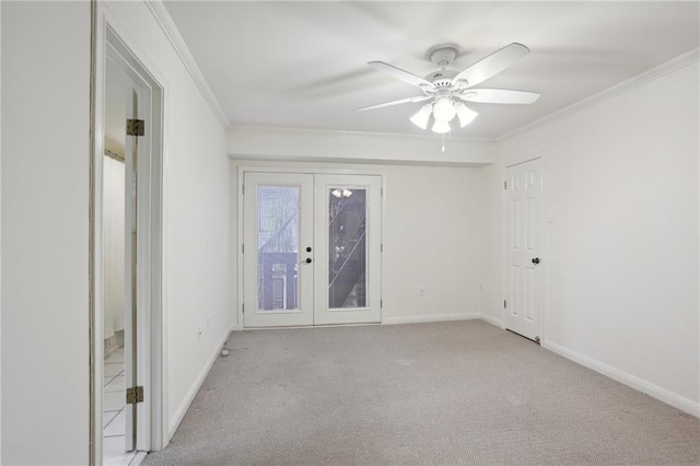 empty room featuring ceiling fan, light colored carpet, ornamental molding, and french doors