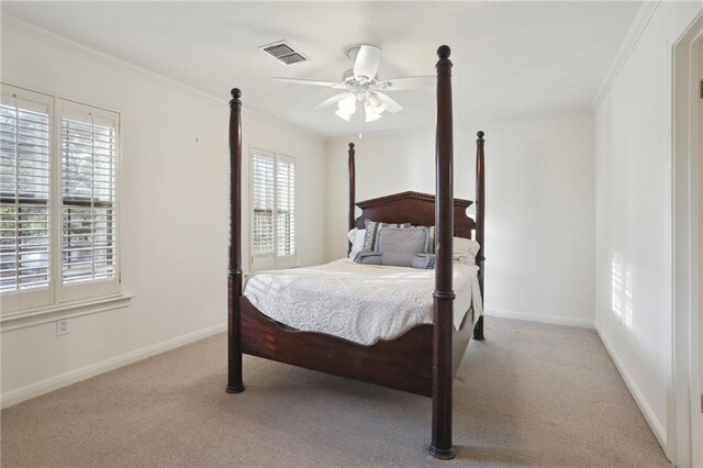 bedroom with multiple windows, ceiling fan, crown molding, and light carpet