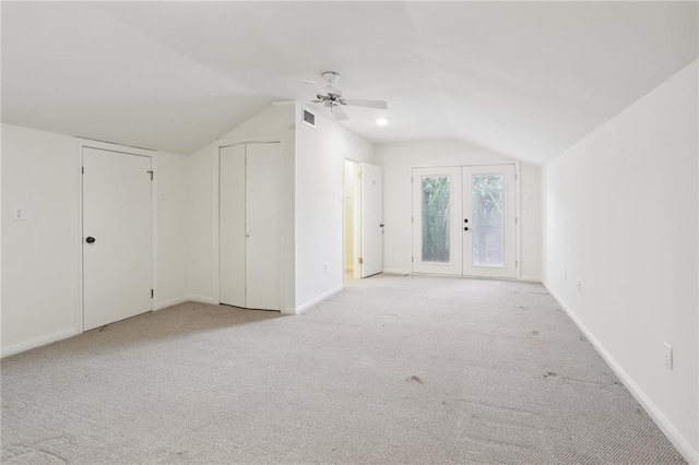 additional living space featuring ceiling fan, french doors, light carpet, and vaulted ceiling