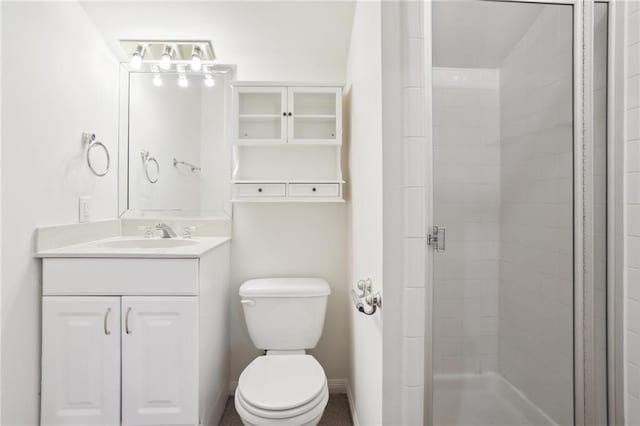 bathroom with vanity, toilet, and a shower with door