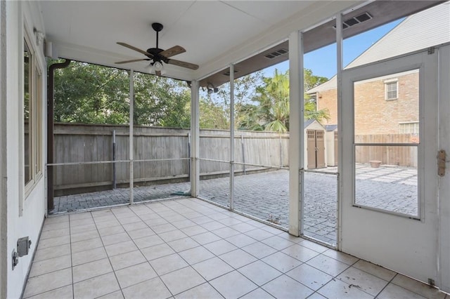 unfurnished sunroom with ceiling fan and a healthy amount of sunlight