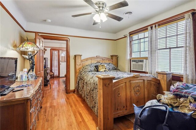 bedroom featuring ceiling fan, cooling unit, and light wood-type flooring