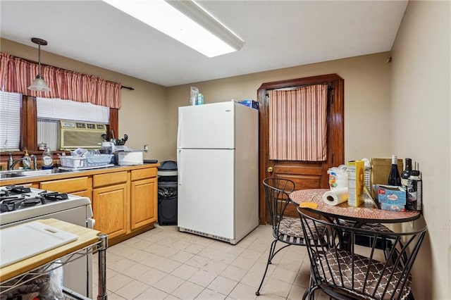 kitchen featuring sink, white fridge, and pendant lighting