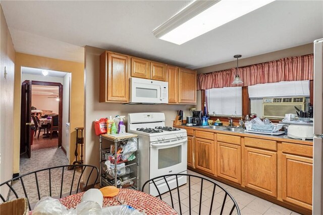 kitchen with white appliances, decorative light fixtures, cooling unit, and sink