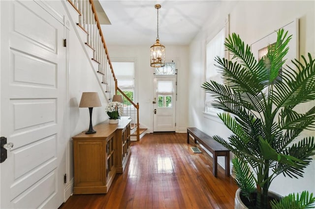 doorway to outside with dark hardwood / wood-style flooring and an inviting chandelier