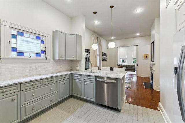 kitchen with light hardwood / wood-style flooring, kitchen peninsula, pendant lighting, gray cabinets, and appliances with stainless steel finishes