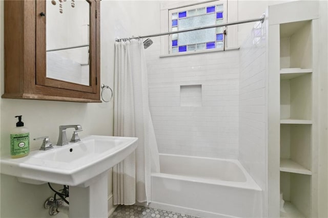 bathroom with built in features, shower / bathtub combination with curtain, and sink