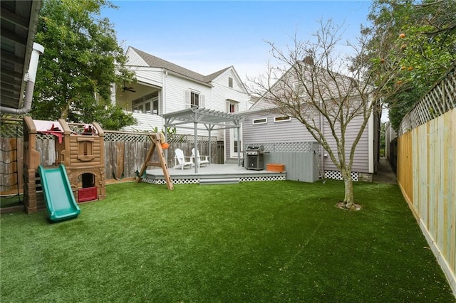 back of property with a playground, a pergola, a yard, and a deck