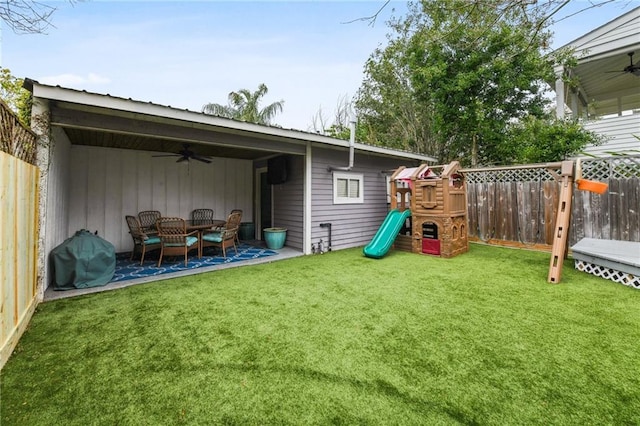 exterior space with a yard, a playground, and ceiling fan