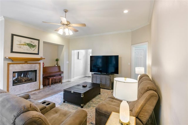 living room with ceiling fan, light hardwood / wood-style floors, ornamental molding, and a fireplace