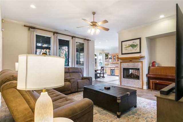 living room with ceiling fan, light hardwood / wood-style floors, and ornamental molding