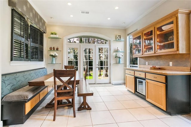 kitchen with ornamental molding, light tile patterned floors, and french doors