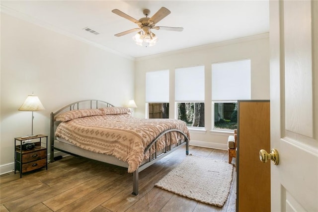 bedroom with hardwood / wood-style flooring, ceiling fan, and crown molding