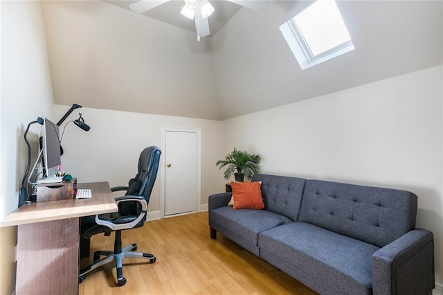 office featuring vaulted ceiling with skylight, ceiling fan, and light hardwood / wood-style flooring