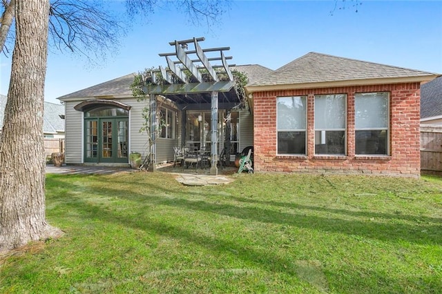 rear view of property featuring a pergola, a patio area, french doors, and a lawn