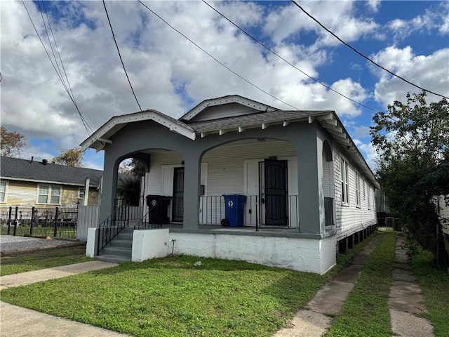 bungalow-style home with covered porch and a front yard