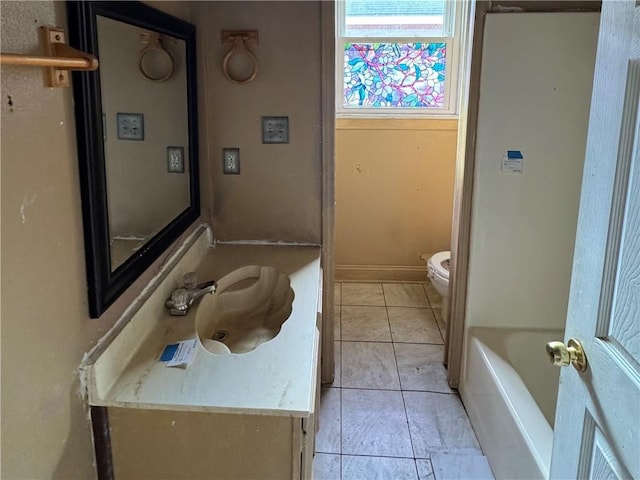 bathroom featuring tile patterned flooring, a bath, vanity, and toilet