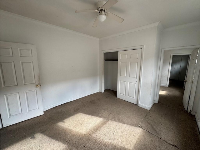 unfurnished bedroom with ceiling fan, dark carpet, ornamental molding, and a closet