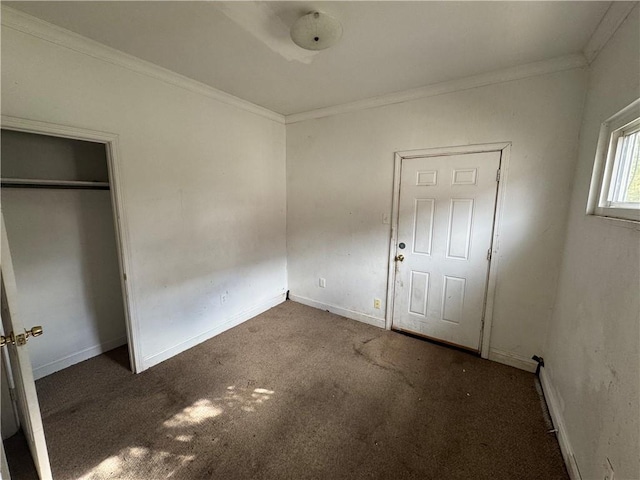 unfurnished bedroom featuring dark colored carpet and ornamental molding