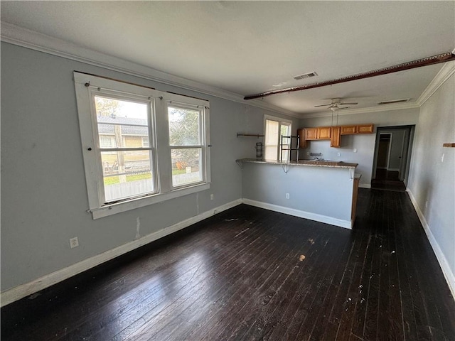 kitchen with a breakfast bar, dark wood-type flooring, ceiling fan, ornamental molding, and kitchen peninsula