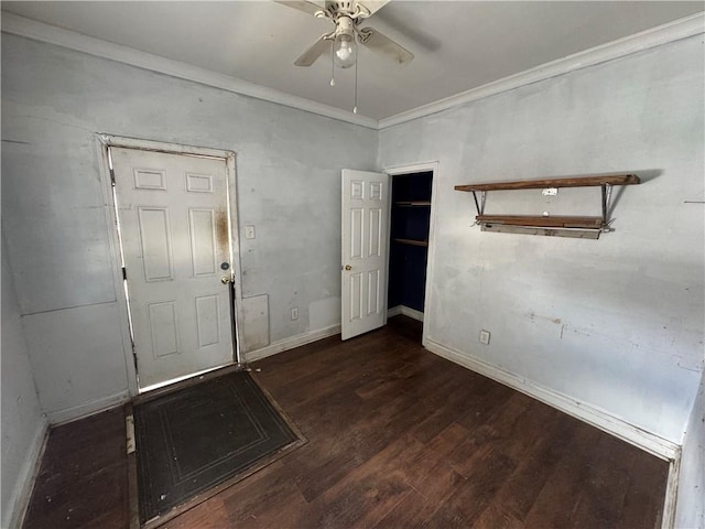 empty room with ceiling fan, dark hardwood / wood-style flooring, and crown molding