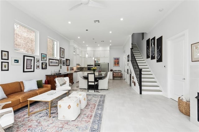 living room featuring ceiling fan and crown molding