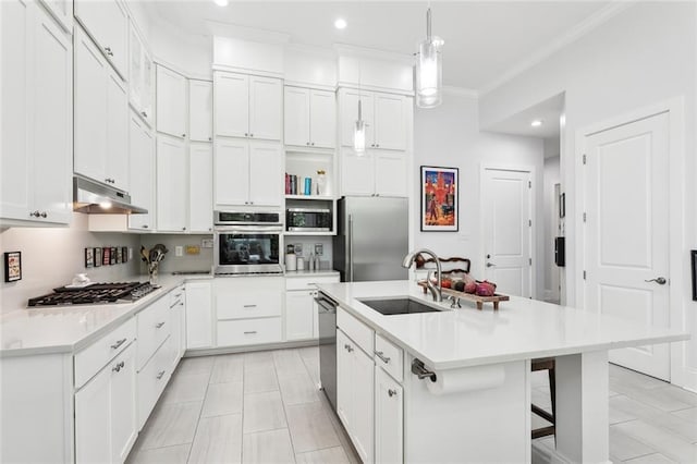 kitchen featuring hanging light fixtures, sink, an island with sink, appliances with stainless steel finishes, and white cabinetry