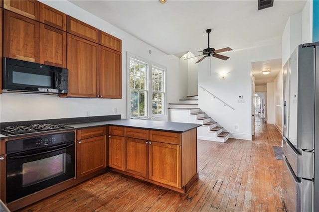 kitchen with black appliances, ceiling fan, kitchen peninsula, and hardwood / wood-style floors