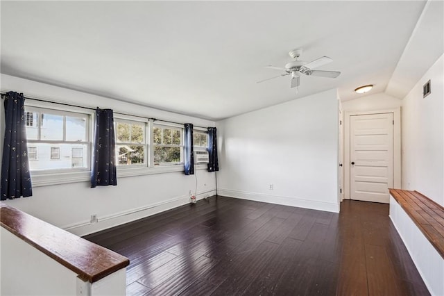 spare room with dark hardwood / wood-style floors, vaulted ceiling, and ceiling fan