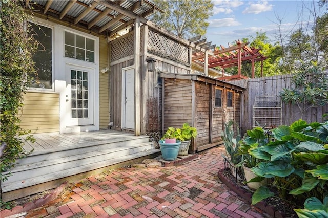 doorway to property featuring a pergola and a wooden deck