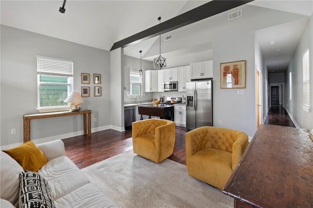 living room with hardwood / wood-style floors, lofted ceiling with beams, and a healthy amount of sunlight