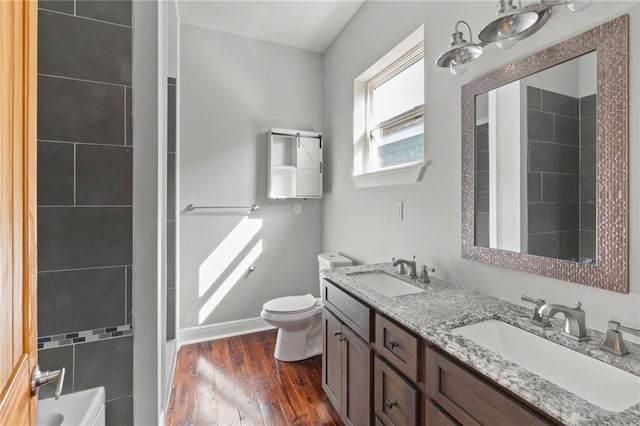 bathroom with hardwood / wood-style floors, vanity, and toilet