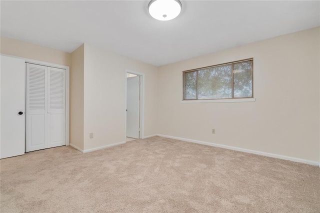 unfurnished bedroom featuring a closet and light colored carpet